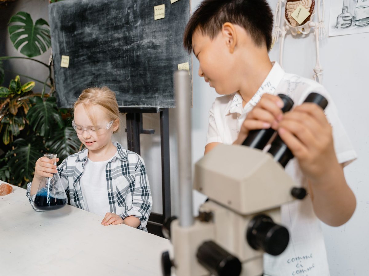 Dos alumnos experimentando con un microscopio en el laboratorio
