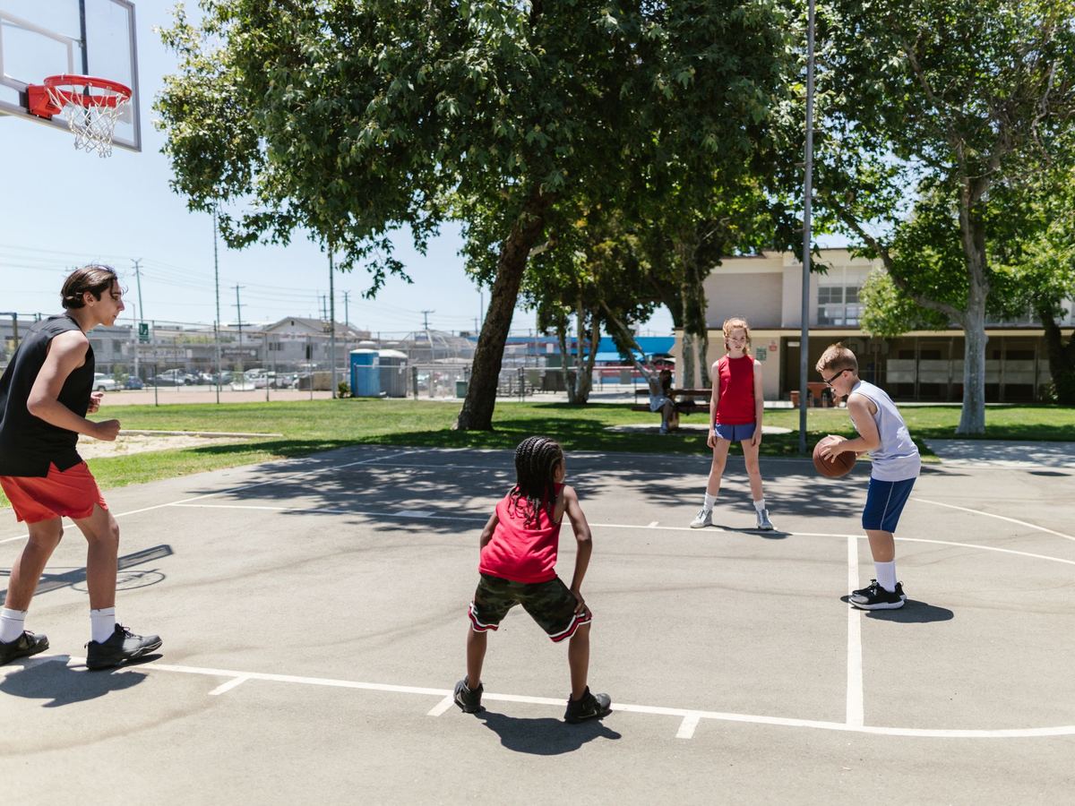 Alumnos jugando al básquet en la cancha del colegio